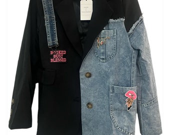 May include: A black blazer with a denim panel on the right side, featuring a pocket and decorative pins. The left side has a denim strap and a pink patch that reads "BOOKED BUSY BLESSED". A tag reads "CHIC".