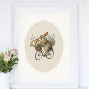 May include: A brown rabbit wearing a blue bow tie rides a blue bicycle with a basket full of flowers. The bicycle is in an oval frame with a beige background. The image is surrounded by a white frame.