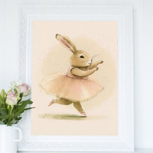 May include: A framed illustration of a brown rabbit wearing a pink tutu and ballet shoes, dancing on a light beige background.