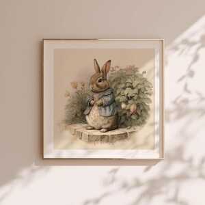 Peut inclure: Une illustration vintage d'un lapin brun portant une veste bleue debout sur un chemin de pierre dans un jardin avec des feuilles vertes et des fleurs roses.