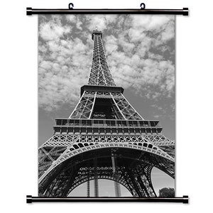 Puede incluir: Una fotografía en blanco y negro de la Torre Eiffel en París, Francia. La torre es una estructura metálica con detalles intrincados y se alza sobre un cielo nublado.