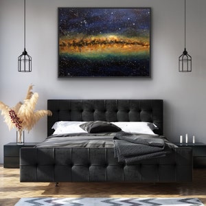 May include: A black tufted headboard bed with a white duvet and a black throw blanket. A framed painting of a starry night sky with a galaxy of stars hangs above the bed.