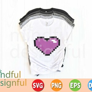 May include: A stack of t-shirts in various colors, including white, gray, and black. The white shirt features a pixelated purple heart design. The image also includes the text "mindful designful" and file type icons.
