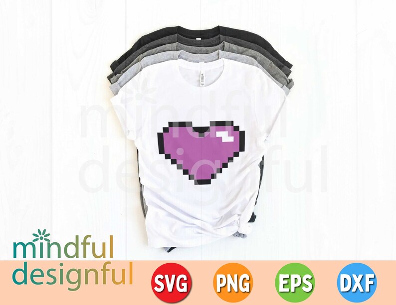May include: A stack of t-shirts in various colors, including white, gray, and black. The white shirt features a pixelated purple heart design. The image also includes the text "mindful designful" and file type icons.
