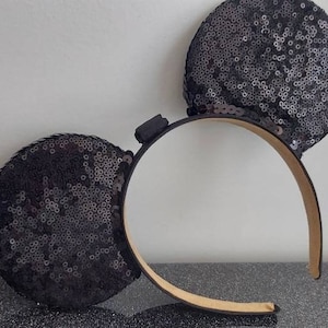 May include: Black sequined mouse ears headband with a brown headband.