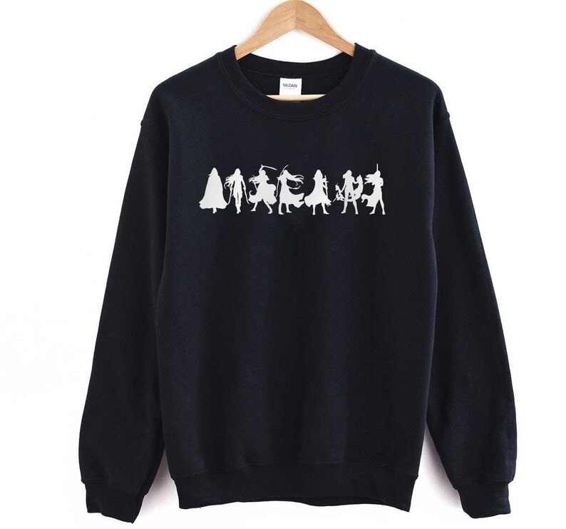 May include: Black sweatshirt with a white silhouette of a group of people in various poses. The people are wearing long robes and appear to be holding swords or other weapons.