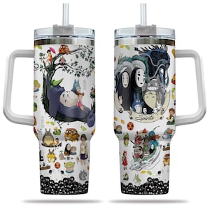 May include: A white tumbler with a handle and straw, decorated with colourful illustrations of characters from the animated films "Spirited Away" and "My Neighbour Totoro." The design includes a large tree and the word "Spirits."