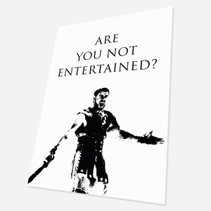 Puede incluir: Imagen en blanco y negro de un hombre con un traje de gladiador, sosteniendo una espada y gritando "ARE YOU NOT ENTERTAINED?"