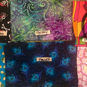 May include: Six different fabric swatches with handwritten labels. The swatches are: Pirates, Paisley, Groovy, Lemons, Peacock, and Daisys.