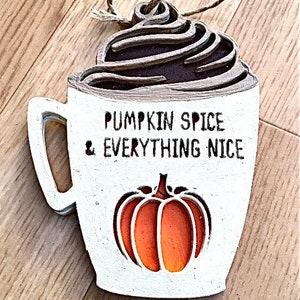 May include: White ceramic mug with a brown whipped cream topping, a pumpkin design, and the text "Pumpkin Spice & Everything Nice".