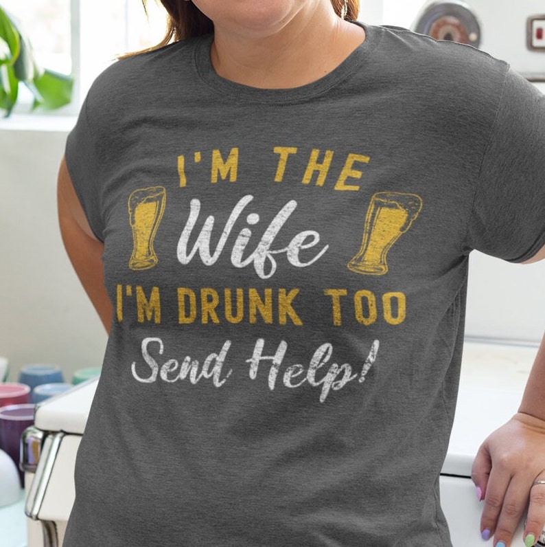 May include: A gray heather t-shirt with the text "I'm the wife I'm drunk too Send Help!" and two beer glasses printed on it.