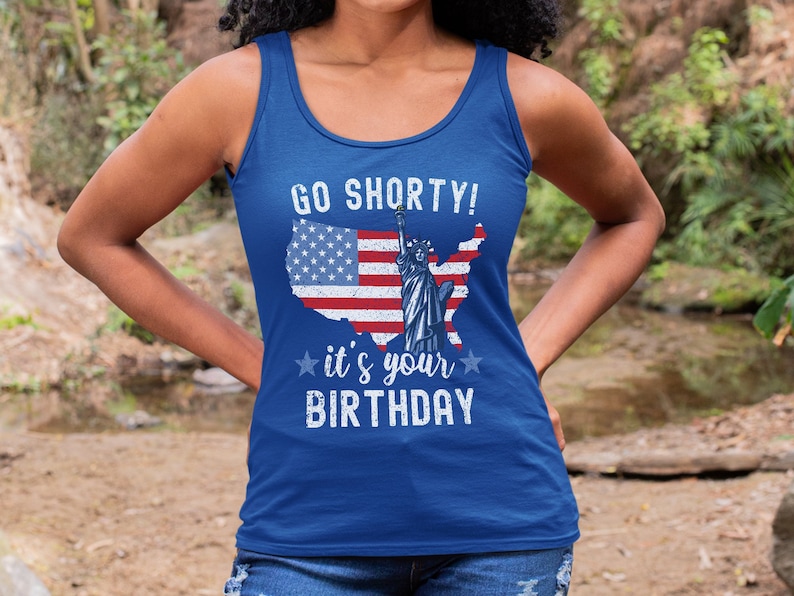 Puede incluir: Un top azul de tirantes con un dise&ntilde;o de bandera estadounidense desgastado y el texto "Go Shorty! It's your Birthday".