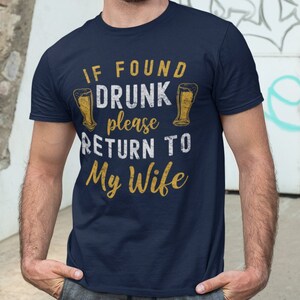 May include: A navy blue t-shirt with the text "If found drunk please return to my wife" and two beer glasses printed on it.