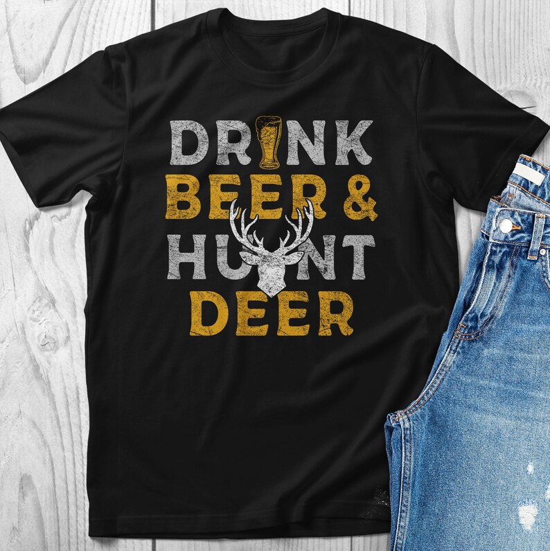May include: Black t-shirt with a distressed yellow graphic that says "Drink Beer & Hunt Deer" with a stylized deer head in the middle.