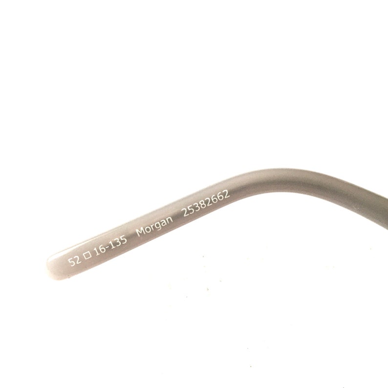 May include: Close-up of the inside of a gray eyeglass frame with the text "52  16-135 Morgan 25382662" printed on it.