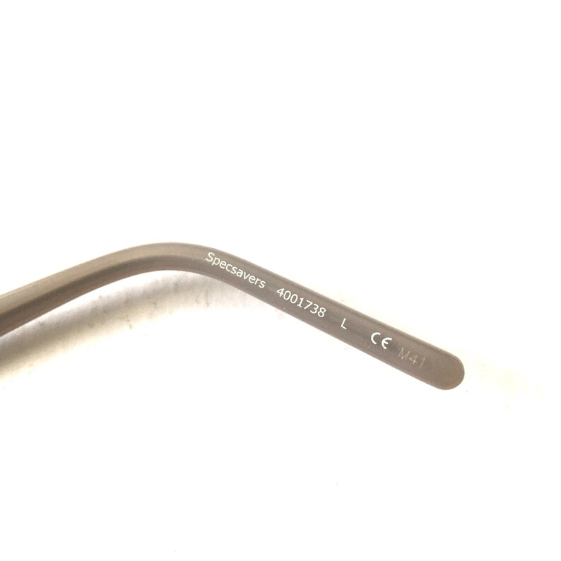 May include: Close-up of the inside of a gray metal eyeglass frame with the text "Specsavers 4001738 L CE M41" printed on it.