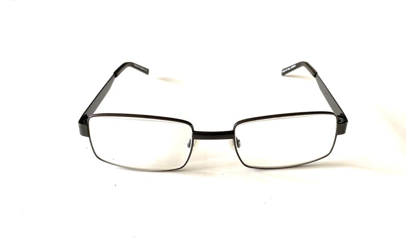 May include: Rectangular eyeglasses with a black metal frame. The lenses are clear, and the arms are thin and extend to the temples. The glasses are set against a white background.