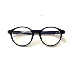 Może przedstawiać: Okulary w czarnych okrągłych oprawkach z przezroczystymi szkłami.