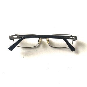 May include: A pair of black and silver eyeglasses with a rectangular frame.