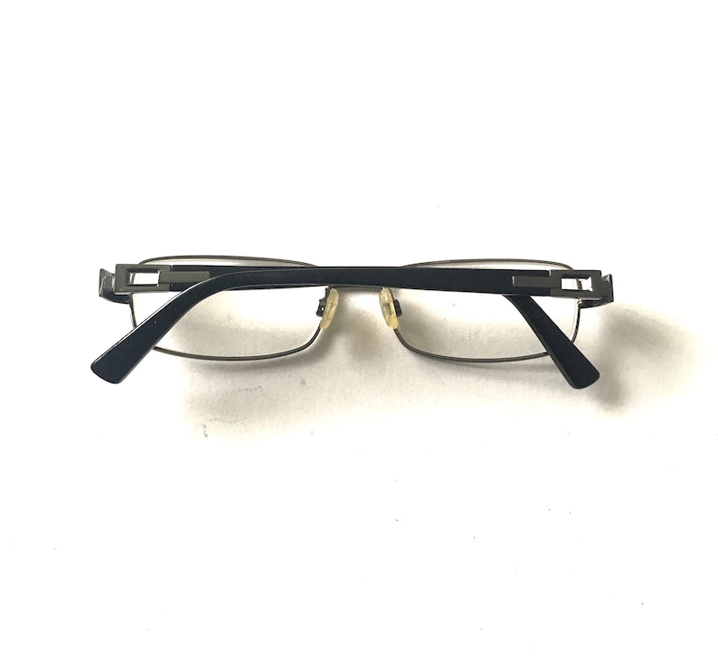 May include: A pair of black and silver eyeglasses with a rectangular frame.