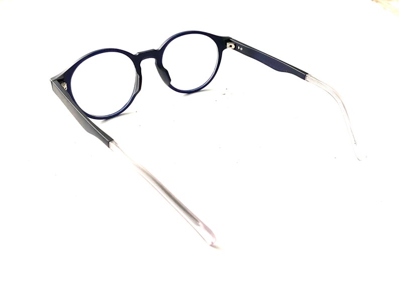 May include: A pair of blue round-framed eyeglasses with clear lenses and thin silver arms.