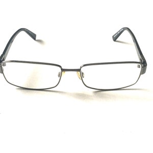 May include: A pair of black metal frame eyeglasses with clear lenses.