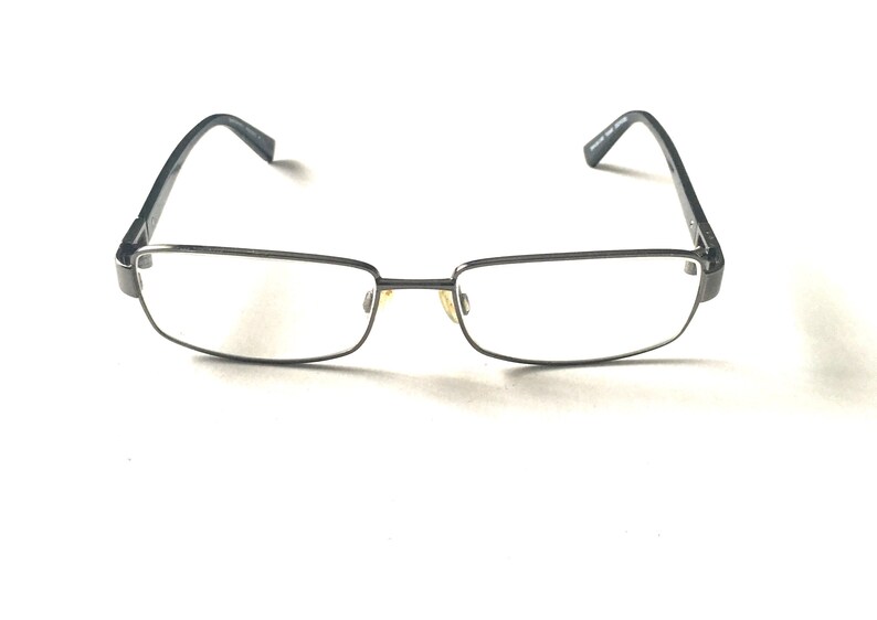 May include: A pair of black metal frame eyeglasses with clear lenses.