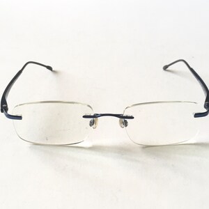 May include: A pair of black rimless glasses with clear lenses.