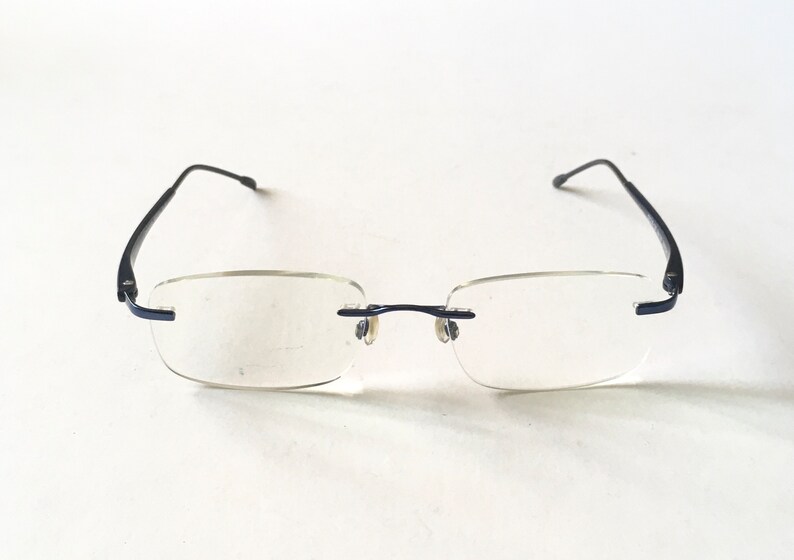 May include: A pair of black rimless glasses with clear lenses.