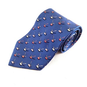 May include: A blue necktie featuring a repeating pattern of small, stylised red and white plungers with wooden-coloured handles. The tie is folded into a roll, displaying the smooth fabric texture and the consistent orientation of the graphic print.