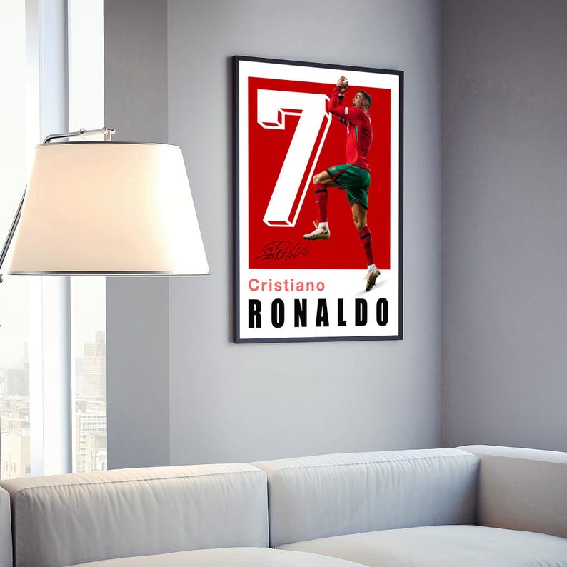 May include: A red and white poster with a photo of Cristiano Ronaldo celebrating a goal. The poster has the number 7 in white and the text "Cristiano Ronaldo" in black.