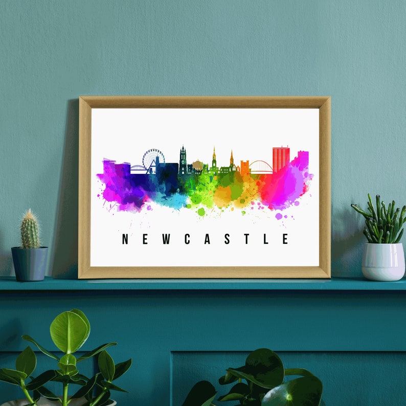 May include: A watercolor painting of the Newcastle skyline with a rainbow color scheme. The skyline includes the Tyne Bridge, the Sage Gateshead, and the Millennium Bridge. The text "NEWCASTLE" is printed below the skyline.