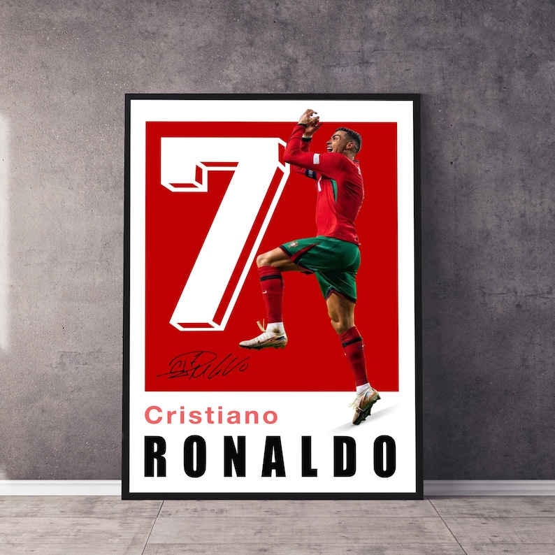 May include: A red and white poster with a photo of a soccer player wearing a red and green jersey. The player is jumping in the air with his arm raised. The number "7" is in large white letters in the background. The text "Cristiano Ronaldo" is at the bottom of the poster.