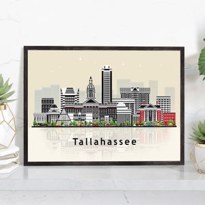 May include: Black and white illustration of the Tallahassee skyline with a beige background. The city's buildings are reflected in a body of water at the bottom of the image. The text "Tallahassee" is printed below the skyline.