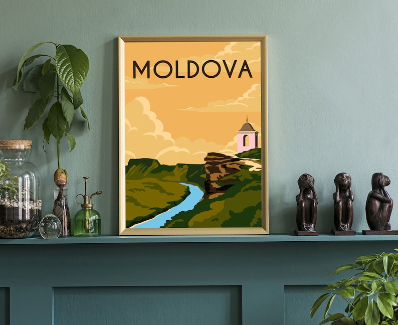 May include: A vintage travel poster with a gold frame featuring a landscape scene of a river winding through a valley with a small pink church on a cliff. The poster has the word "MOLDOVA" in bold, yellow letters at the top.