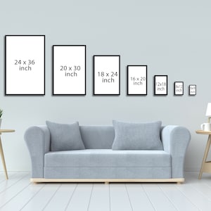 May include: A white wall with a row of black picture frames of different sizes. The frames are empty and have the dimensions listed in inches. A light gray sofa sits in front of the wall. A small table with a lamp and a cup sits on the right side of the image.
