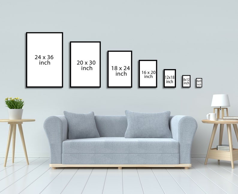 May include: A white wall with a row of black picture frames of different sizes. The frames are empty and have the dimensions listed in inches. A light gray sofa sits in front of the wall. A small table with a lamp and a cup sits on the right side of the image.