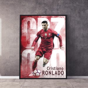 Puede incluir: Un p&oacute;ster rojo y blanco con un jugador de f&uacute;tbol con una camiseta roja con el n&uacute;mero 7 en la espalda. El jugador est&aacute; regateando un bal&oacute;n de f&uacute;tbol. El texto "Cristiano Ronaldo" est&aacute; impreso en blanco en la parte inferior del p&oacute;ster.
