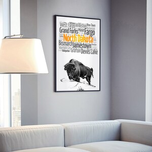May include: A black and white illustration of a buffalo with a word cloud of cities in North Dakota. The word cloud includes the cities of West Fargo, Williston, New Town, Grand Forks, Fargo, Bismarck, Jamestown, Watford City, Grafton, and Devils Lake. The word "North Dakota" is highlighted in orange.