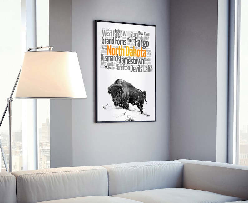 May include: A black and white illustration of a buffalo with a word cloud of cities in North Dakota. The word cloud includes the cities of West Fargo, Williston, New Town, Grand Forks, Fargo, Bismarck, Jamestown, Watford City, Grafton, and Devils Lake. The word "North Dakota" is highlighted in orange.