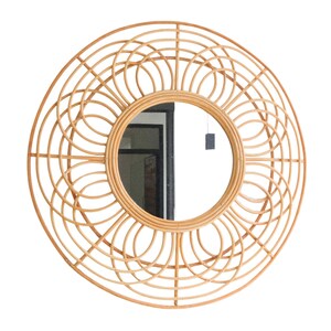 May include: A large round mirror with a woven rattan frame. The frame has a sunburst design with a circular mirror in the center.