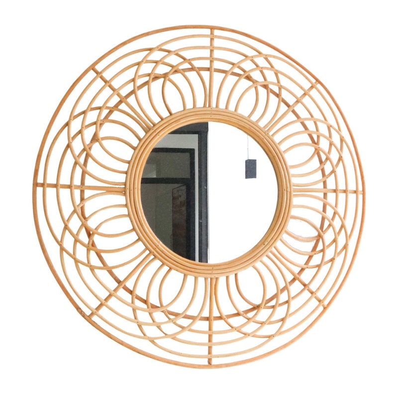 May include: A large round mirror with a woven rattan frame. The frame has a sunburst design with a circular mirror in the center.