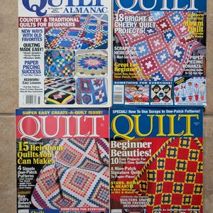 May include: Four vintage "Quilt" magazines are displayed, showcasing colorful quilt patterns. The covers feature titles like "Country & Traditional Quilts for Beginners" and "Beginner Beauties!" with images of finished quilts. The magazines are in good condition.