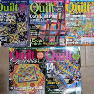 May include: A collection of five "Quilt" magazines, each featuring colorful quilt patterns and designs. The covers display titles like "A Galaxy of Star Quilts," "Dots & Dashes," and "Lazy Dahlias," with additional text promoting quilting techniques and projects.