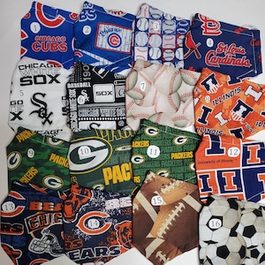 May include: A collection of 16 fabric face masks featuring various sports team logos and designs. The masks are numbered 1 through 16. Some of the logos include the Chicago Cubs, Chicago White Sox, St. Louis Cardinals, Green Bay Packers, University of Illinois, and Chicago Bears.