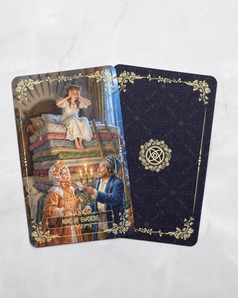 Pu&ograve; includere: Due carte dei tarocchi. La carta anteriore raffigura una scena con una persona su una pila di materassi e due persone che tengono candele. La carta &egrave; etichettata "NINE OF SWORDS". La carta posteriore &egrave; blu scuro con un bordo floreale dorato e un simbolo.