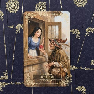 Pu&ograve; includere: Una carta dei tarocchi raffigurante una scena con una donna in abito blu e una strega che offre una mela rossa. La carta &egrave; intitolata "XV. THE DEVIL" ed &egrave; ambientata su uno sfondo blu scuro con motivi floreali dorati.