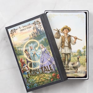Pu&ograve; includere: Un mazzo di tarocchi intitolato "The Fairy Tale Tarot" in una scatola nera. La scatola presenta un'illustrazione colorata di personaggi delle fiabe e un castello. Una carta mostra un giovane con un'oca. Il mazzo &egrave; di Tarocco Studio.