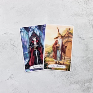 May include: Two tarot cards featuring illustrations. One card depicts a queen in a black dress and red cape, holding a sword, with the text "Queen of Swords." The other card shows a wizard with a staff, labeled "V. The Hierophant."