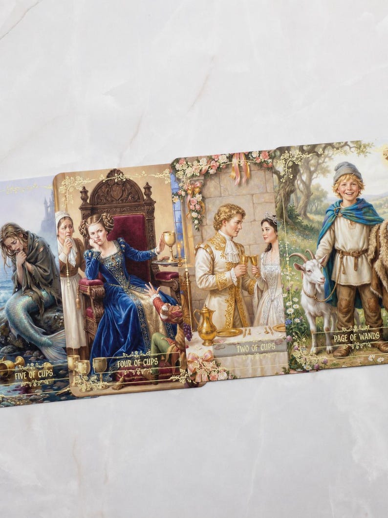 Pu&ograve; includere: Un set di carte dei tarocchi con illustrazioni fantasy. Le carte raffigurano scene con figure in abiti medievali, tra cui una sirena, una regina e un giovane con una capra. Le carte sono etichettate con titoli come "Five of Cups" e "Page of Wands."